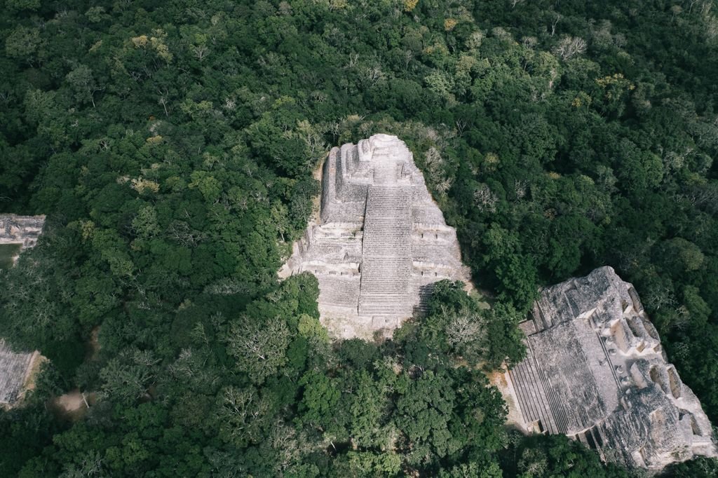A breathtaking aerial shot of an ancient Mayan pyramid nestled in lush jungle.
