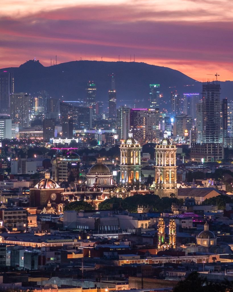 A captivating dusk view of Puebla's illuminated skyline featuring historic and modern architecture.