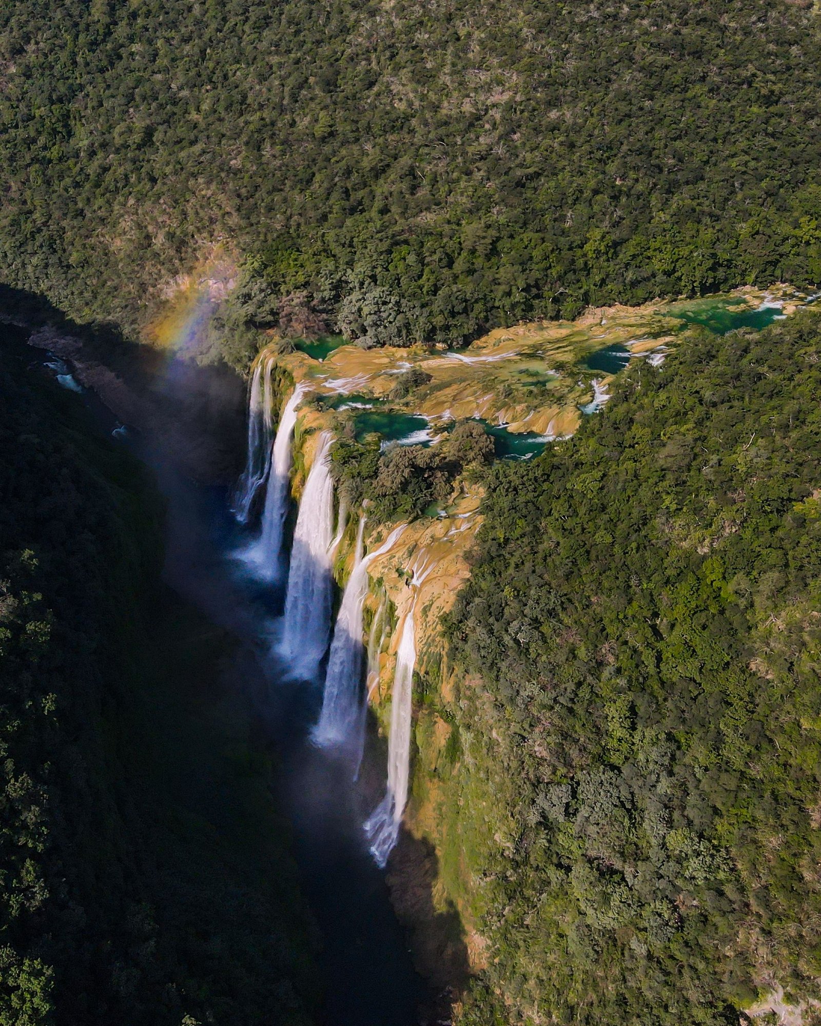 A stunning aerial capture of Tamul Waterfalls in Tamasopo, showcasing lush greenery and vibrant cascades.