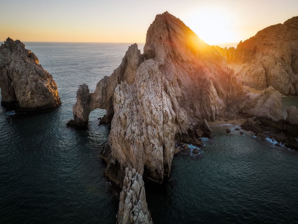 Aerial view of the iconic Land's End rocks in Cabo San Lucas, captured at sunset.