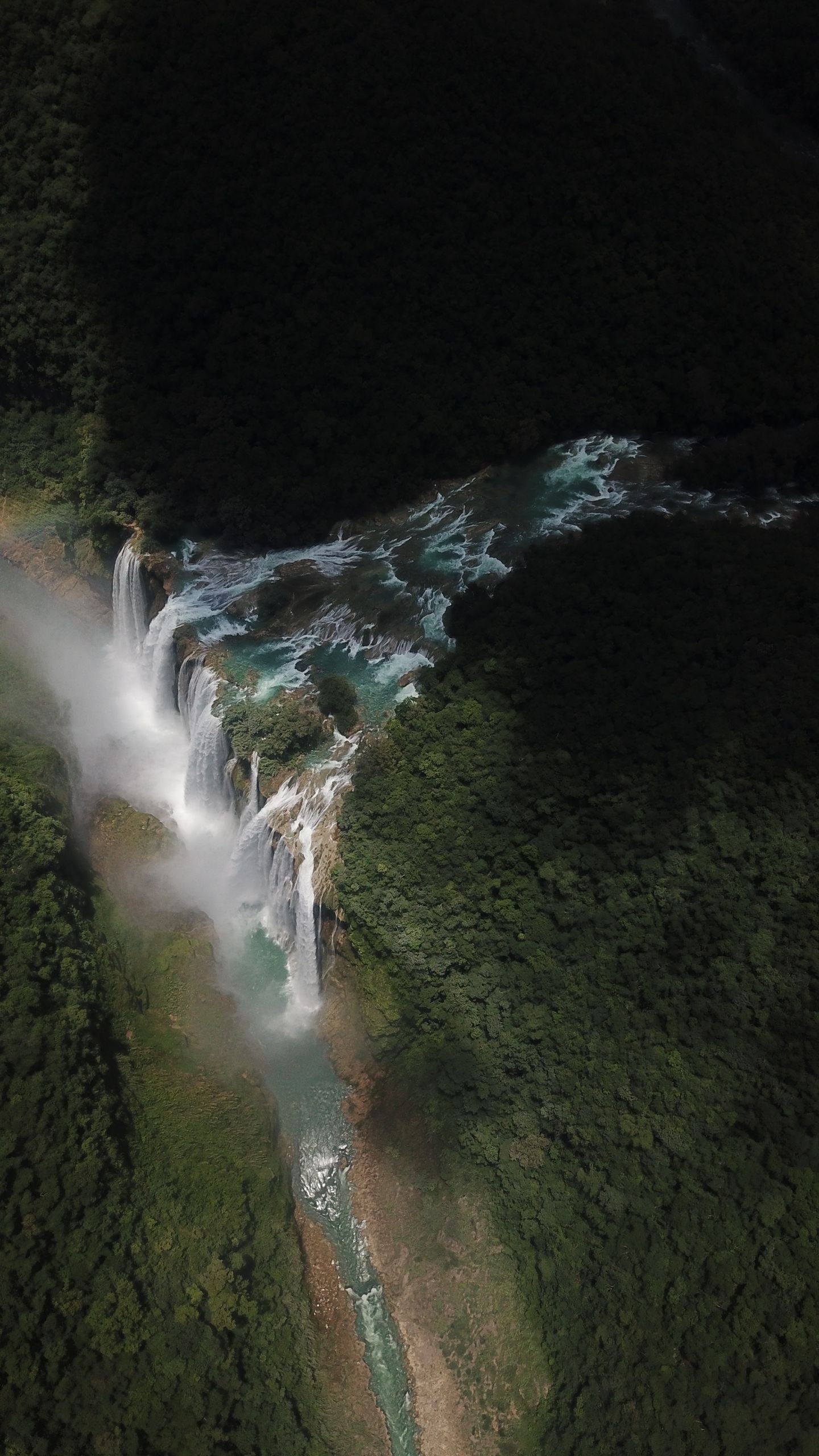 Captivating aerial shot of Tamul Waterfall cascading through lush forest in Aquismón, Mexico.