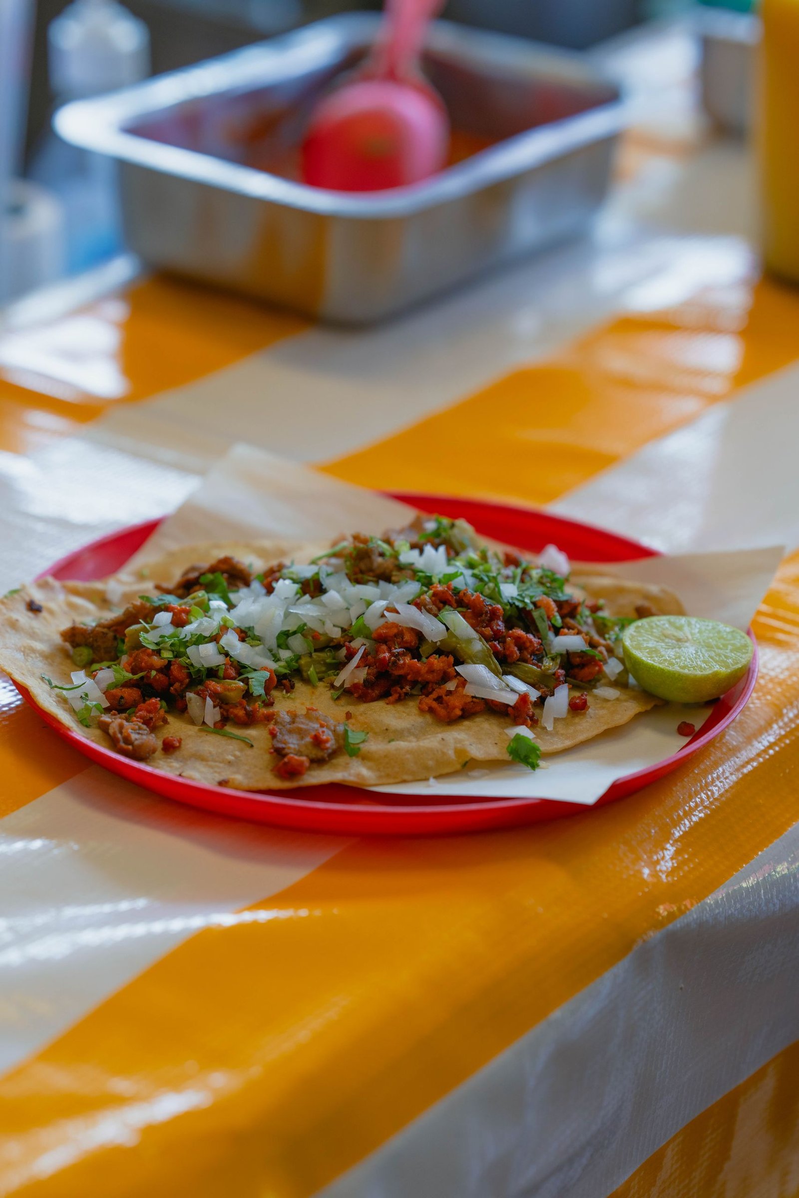 Close-up of a traditional Tlayuda with lime served at a table in Mexico City.