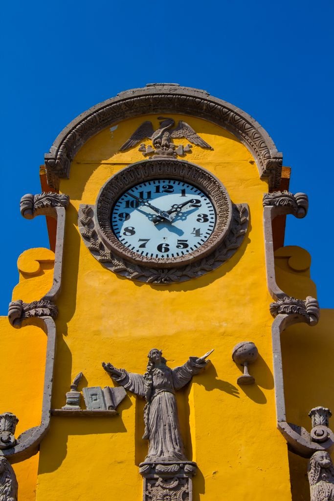 Explore the vibrant architecture of Puebla with this detailed photo of a historic clock tower facade.