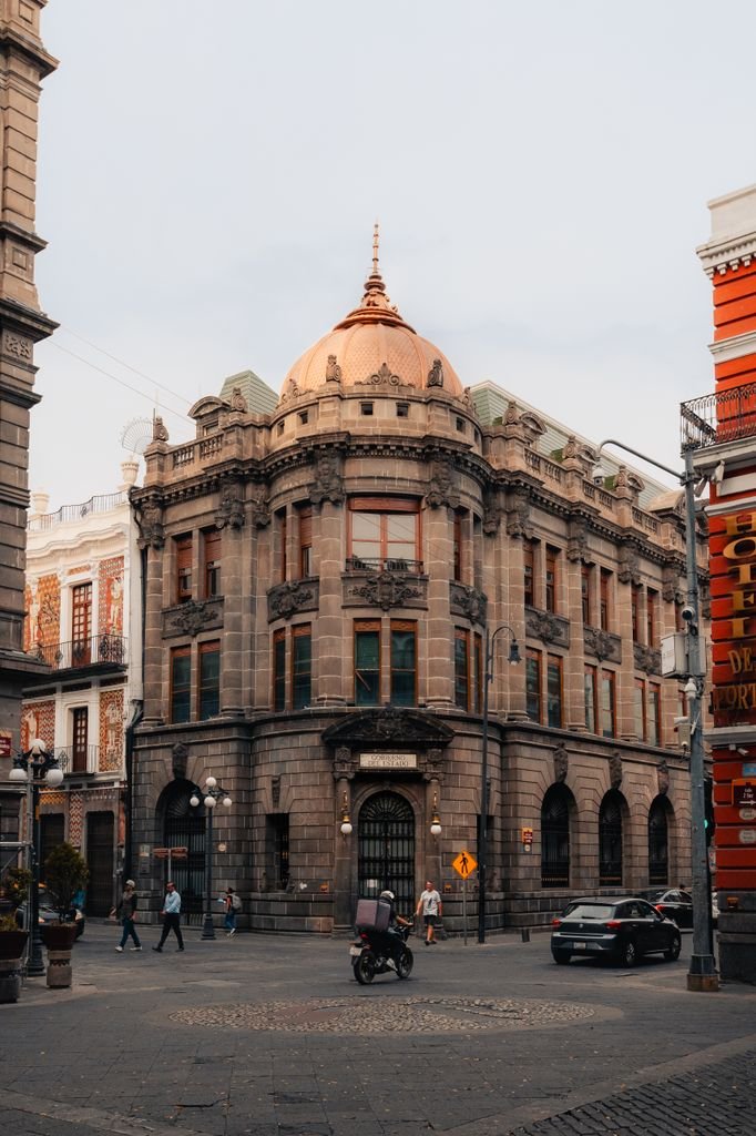 Street view of historic architecture at a busy corner in Puebla, Mexico.
