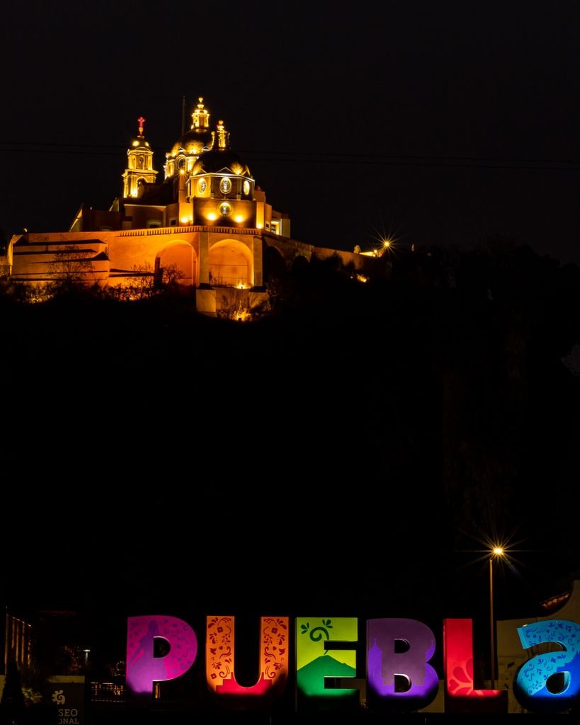 Stunning view of Puebla illuminated letters with church at night in Puebla, Mexico.