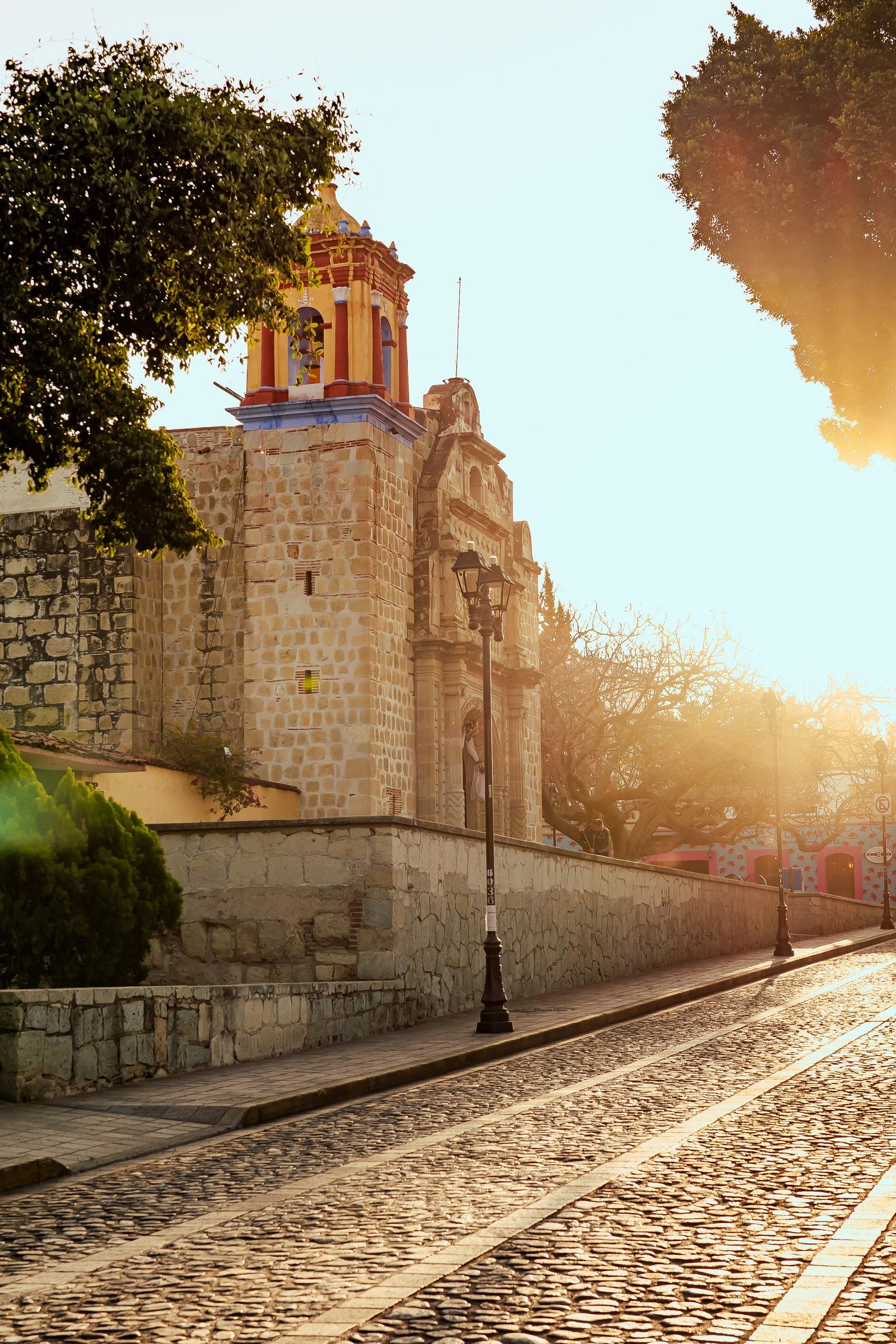 Cobblestone street and historic temple of San Matías Jalatlaco at sunset in Oaxaca de Juárez, Mexico.