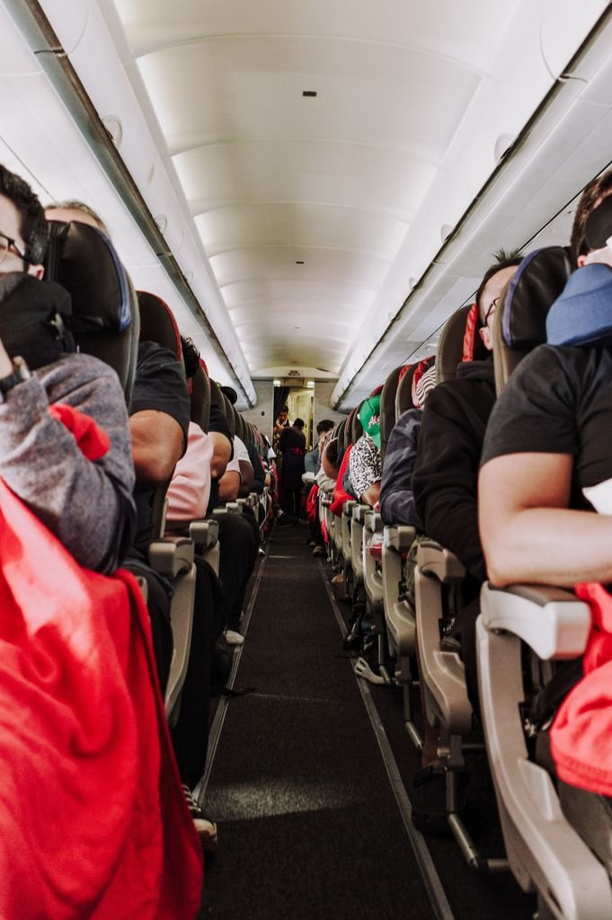 Passengers seated inside a commercial airplane enjoying a comfortable flight.