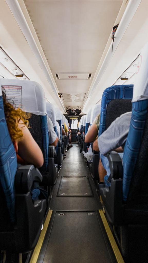 Passengers seated on a bus during a daytime journey, capturing a travel atmosphere.