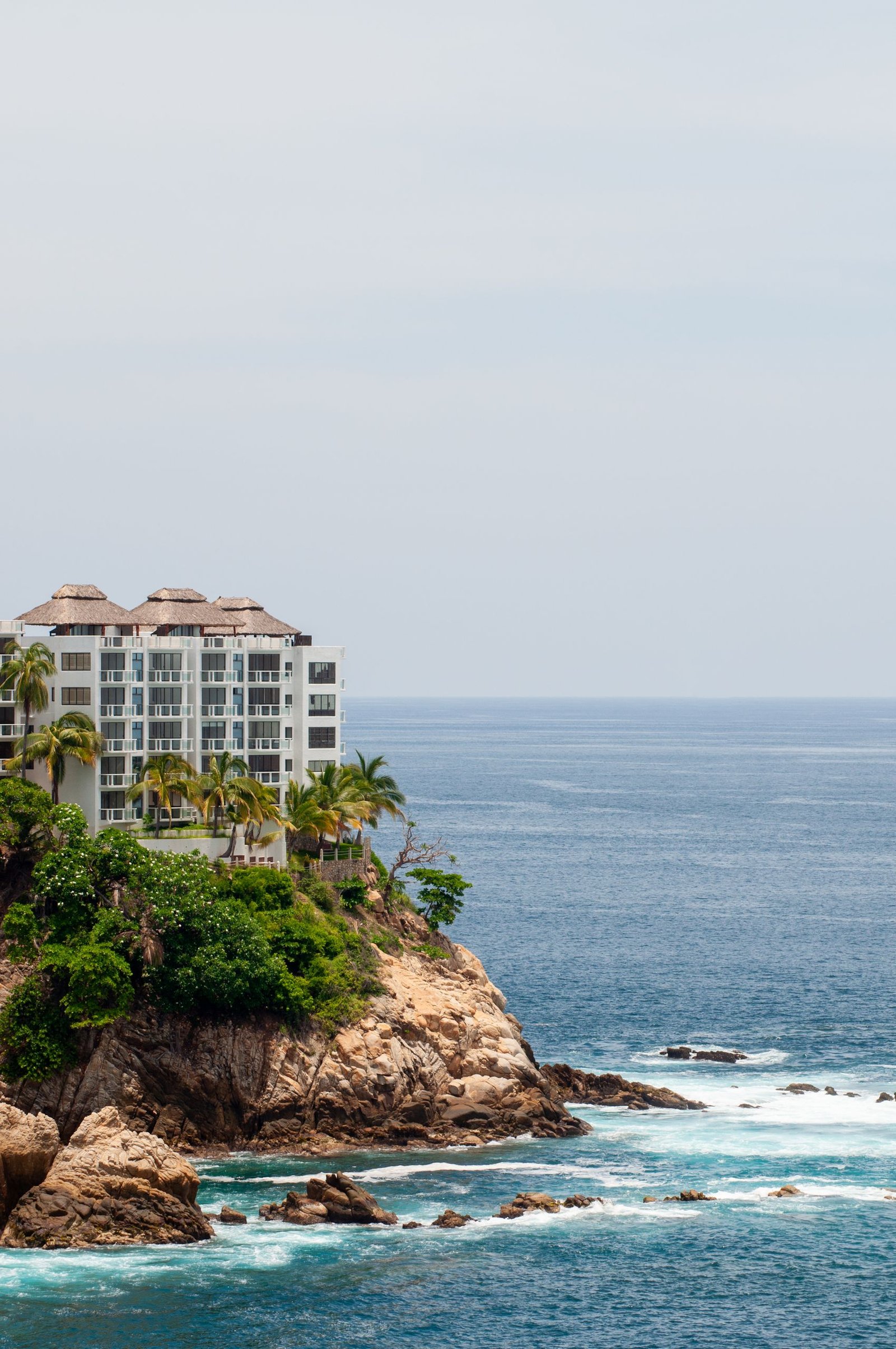 Resort perched on rocky cliffs with ocean view in Acapulco, Mexico.