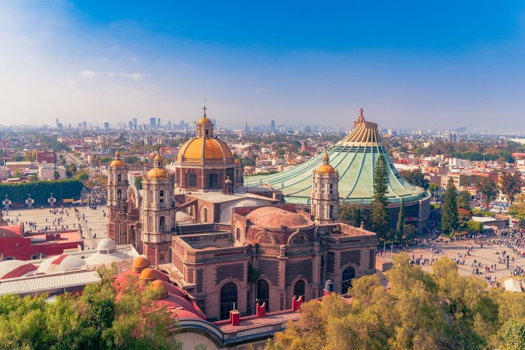 Stunning view of the Basilica of Our Lady of Guadalupe with a Mexico City skyline backdrop, showcasing religious devotion.
