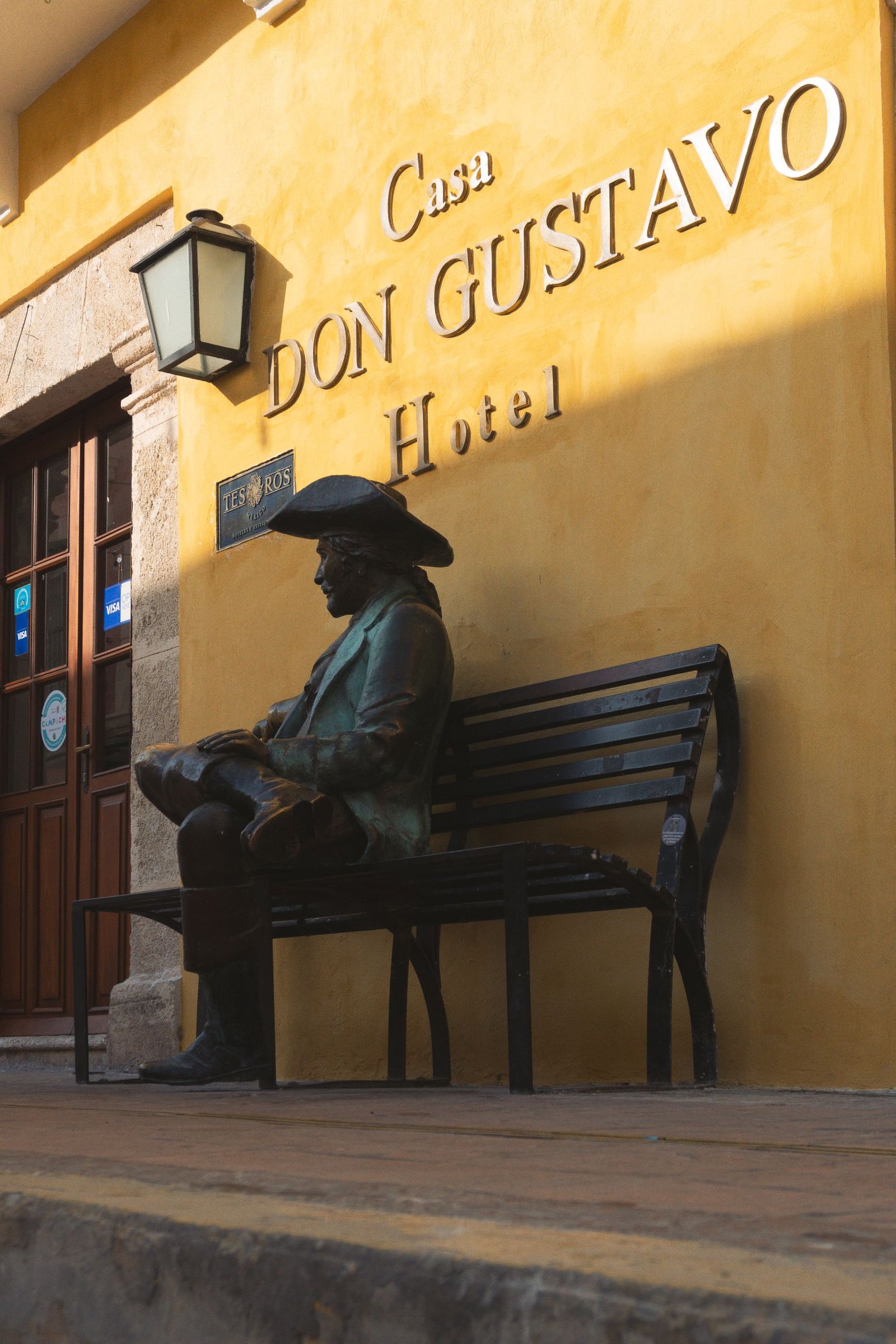 View of Casa Don Gustavo Hotel with a statue in colonial San Francisco de Campeche, México.