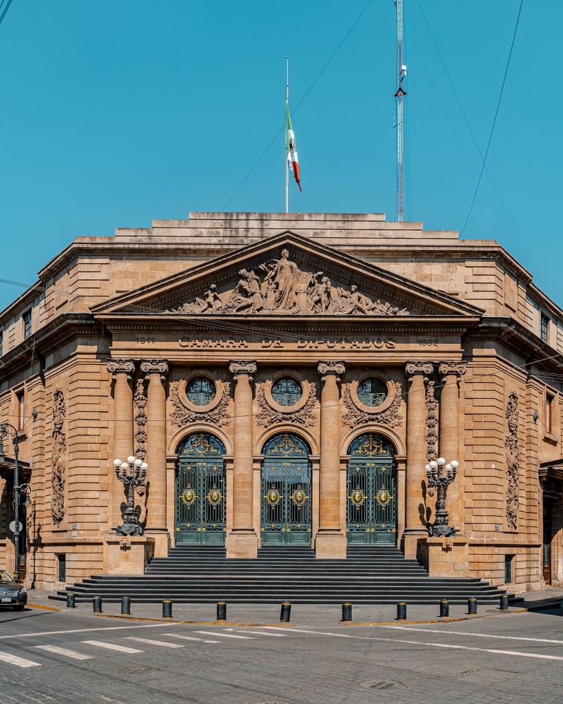 Classic architectural facade of a historic landmark building in Mexico City under a clear blue sky.